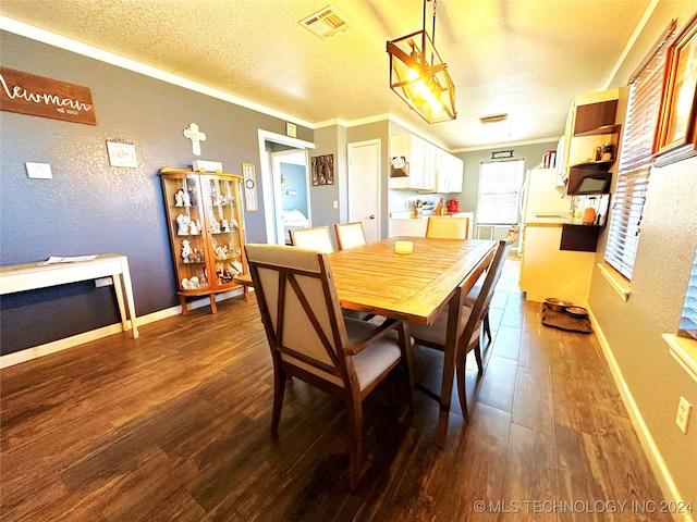 dining area featuring dark hardwood / wood-style floors, ornamental molding, and a textured ceiling