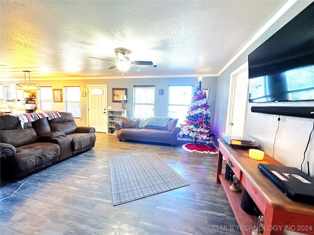 living room featuring crown molding, ceiling fan, wood-type flooring, and a textured ceiling