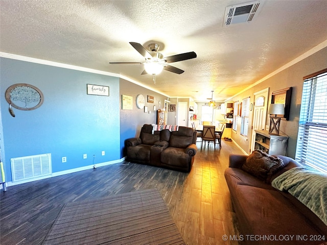 living room featuring ceiling fan, wood-type flooring, a textured ceiling, and ornamental molding