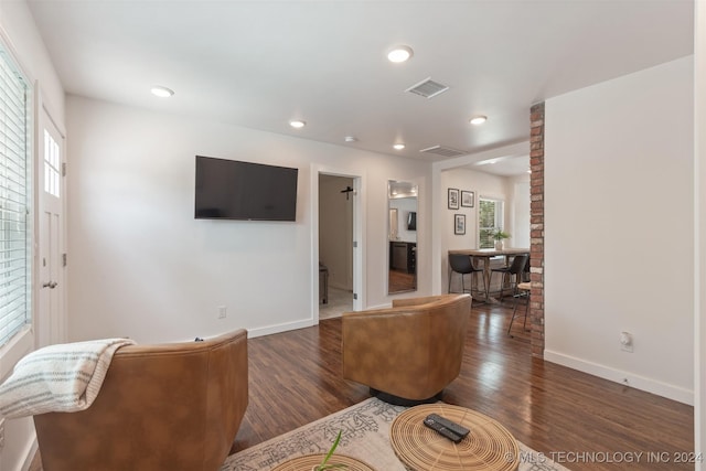 living room with plenty of natural light and dark wood-type flooring