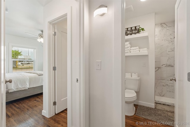 bathroom with hardwood / wood-style flooring, ceiling fan, toilet, and tiled shower