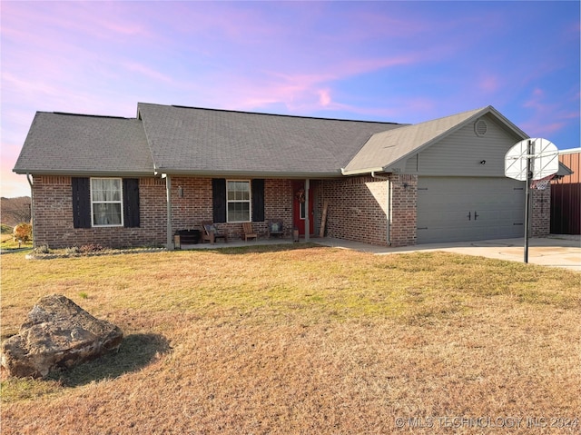 ranch-style house featuring a yard and a garage