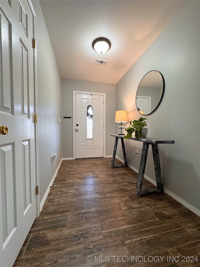 foyer entrance featuring dark hardwood / wood-style flooring and a textured ceiling