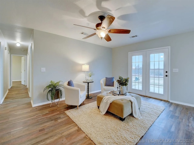 living area with hardwood / wood-style floors and ceiling fan