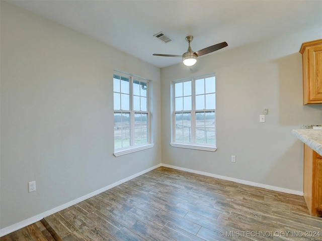 unfurnished dining area with wood-type flooring and ceiling fan