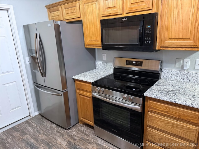 kitchen with light stone counters, stainless steel appliances, and dark hardwood / wood-style floors