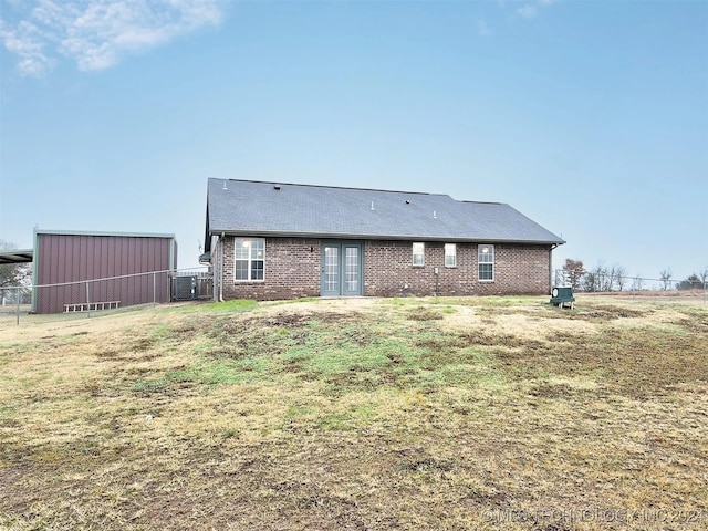 back of house with a yard and central AC