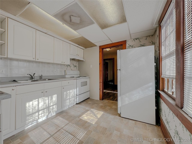 kitchen with range with electric cooktop, tasteful backsplash, sink, white refrigerator, and white cabinets