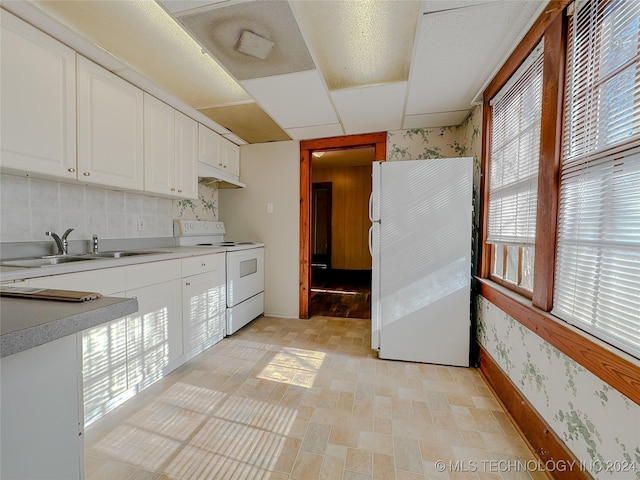 kitchen featuring white cabinets, white appliances, sink, and a wealth of natural light