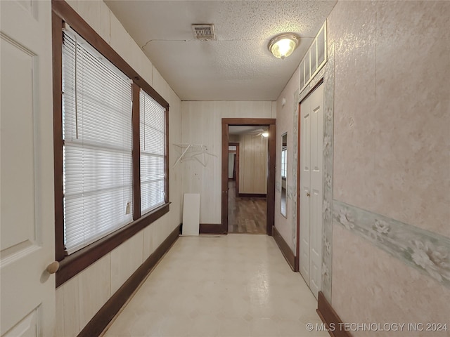 hall with a textured ceiling