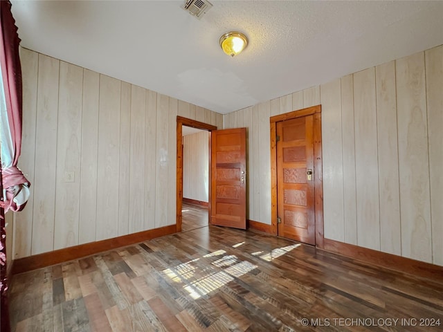 unfurnished room featuring wood walls and wood-type flooring