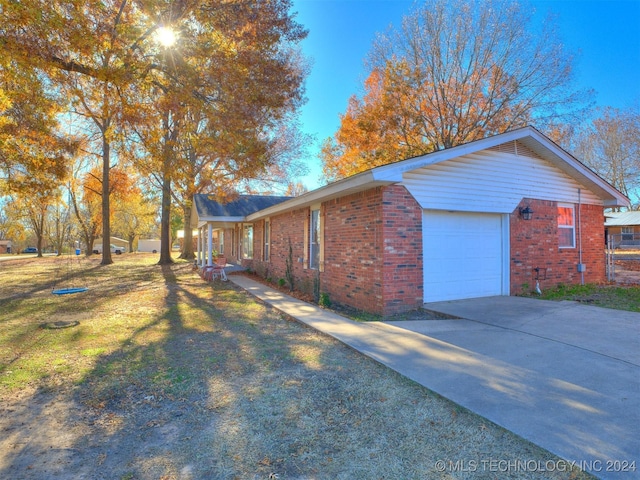 view of side of property featuring a garage and a lawn