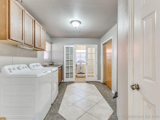 laundry room featuring a wealth of natural light, french doors, cabinets, and a textured ceiling