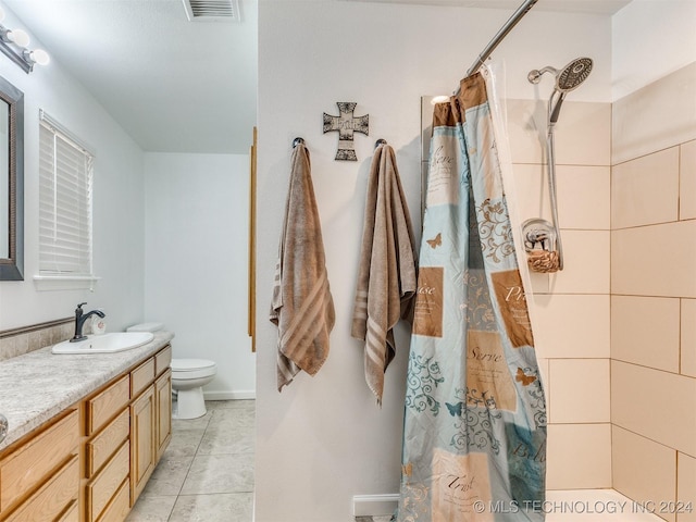 bathroom featuring tile patterned floors, walk in shower, vanity, and toilet