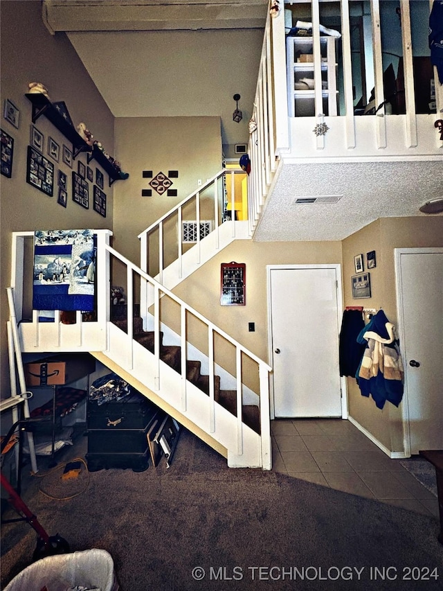 stairs with tile patterned flooring and a textured ceiling