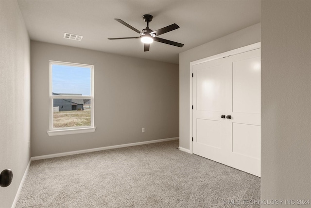 unfurnished bedroom featuring carpet flooring, a closet, and ceiling fan