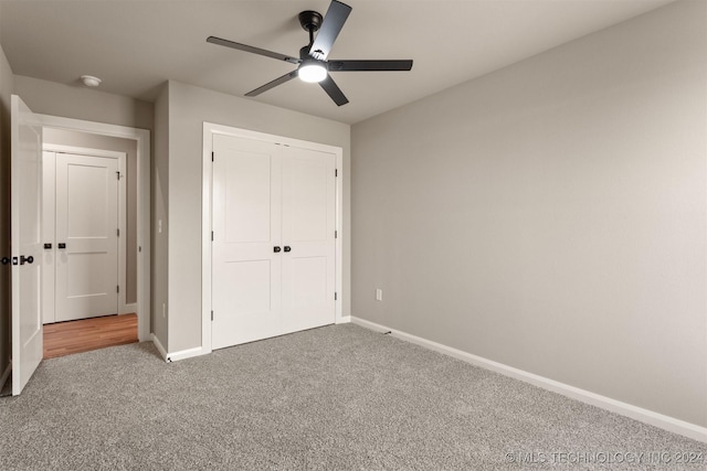 unfurnished bedroom with ceiling fan, a closet, and carpet