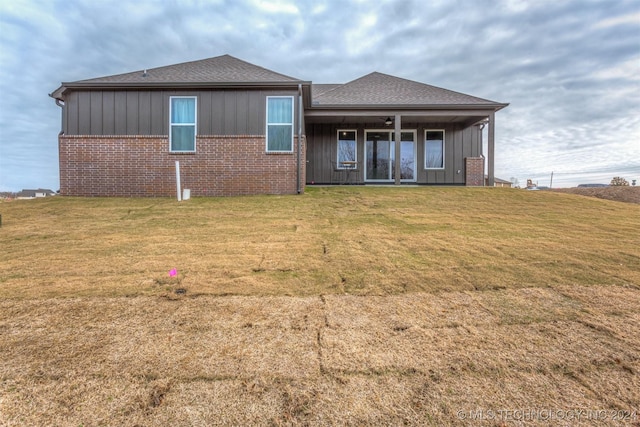 rear view of house featuring a yard