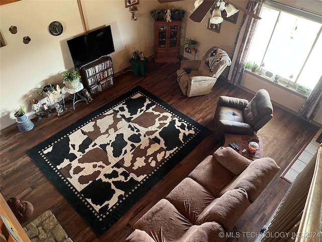 living room with ceiling fan, baseboards, and wood finished floors