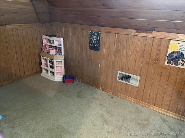 interior space with wooden walls, visible vents, and carpet floors