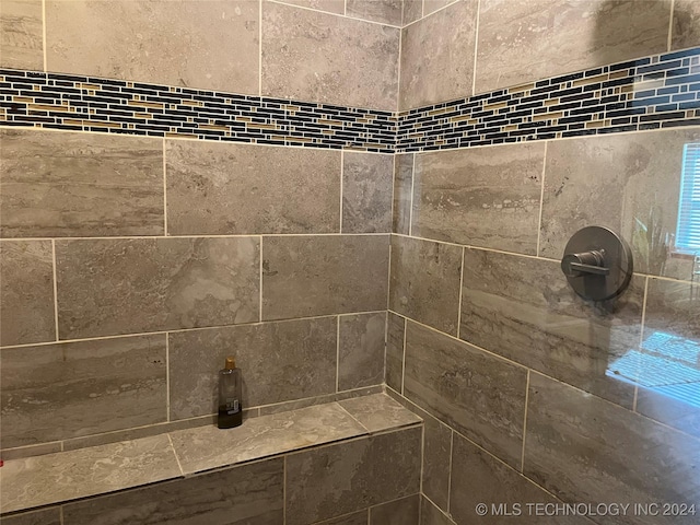 interior details featuring a tile shower