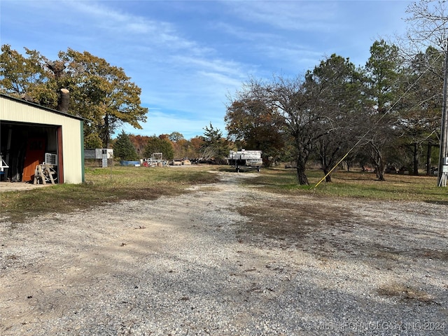 view of road with a pole building and dirt driveway
