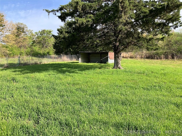view of yard with an outbuilding, fence, and an outdoor structure