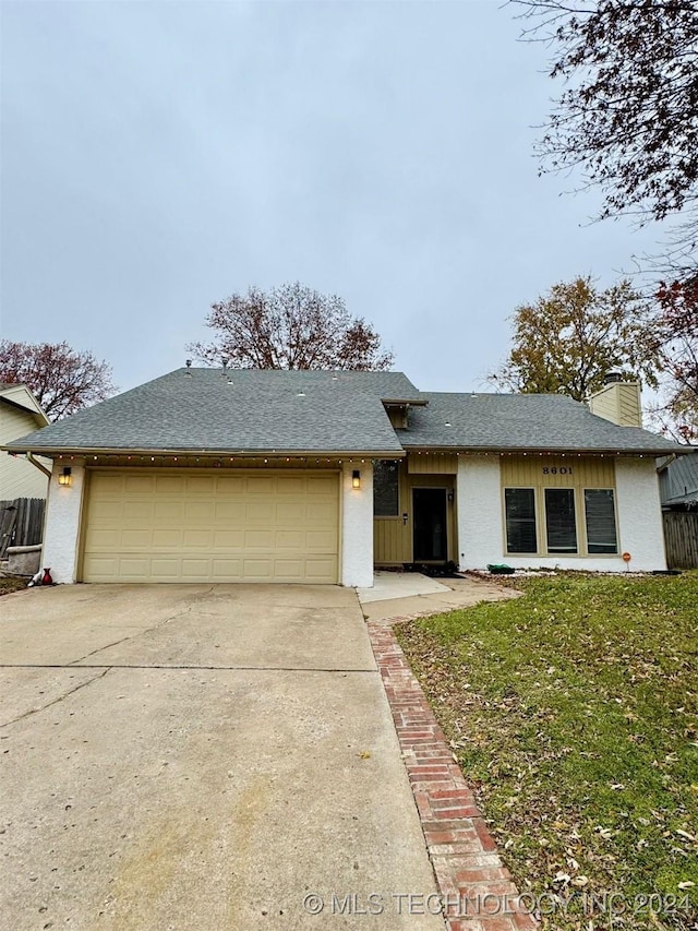 view of front of house with a front yard and a garage