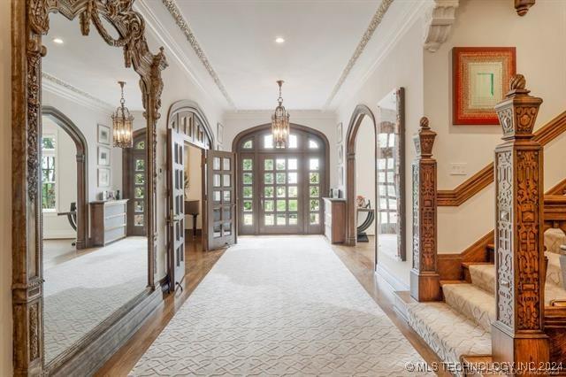 entryway with light hardwood / wood-style floors, ornamental molding, and french doors