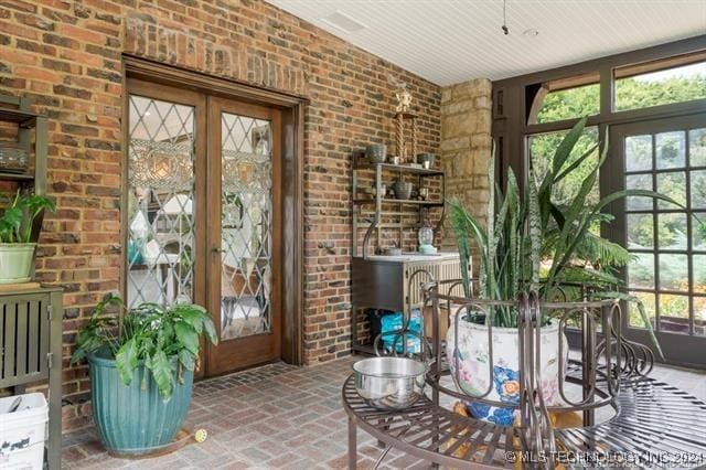 doorway to outside featuring french doors and brick wall