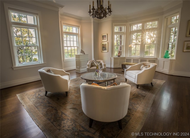 sitting room with crown molding, dark hardwood / wood-style flooring, and a chandelier