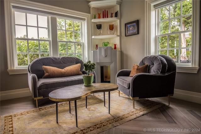 sitting room with a healthy amount of sunlight, parquet flooring, and a fireplace