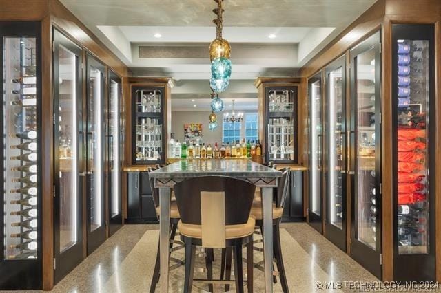 bar featuring a tray ceiling, french doors, and decorative light fixtures