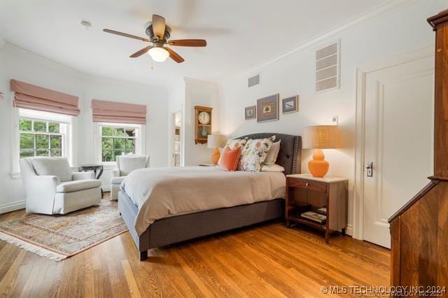 bedroom featuring ceiling fan, light hardwood / wood-style floors, and ornamental molding