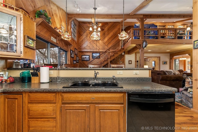 kitchen with dishwasher, wood-type flooring, wood walls, and sink