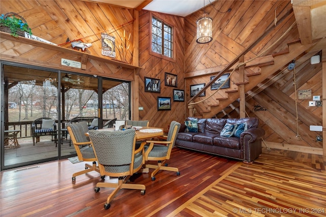 dining area featuring wood walls, high vaulted ceiling, wood-type flooring, and wooden ceiling