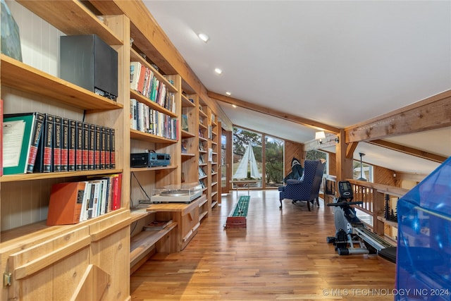 interior space with wood-type flooring, lofted ceiling with beams, and wood walls