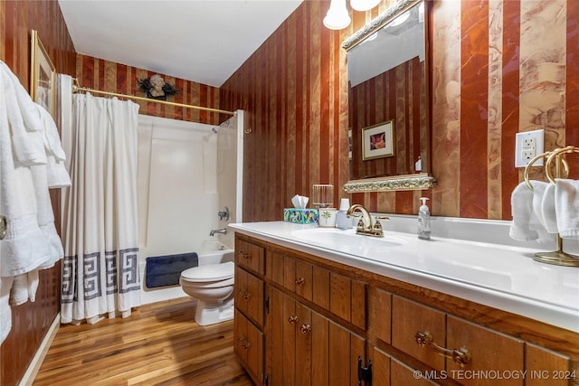 full bathroom with shower / bath combo, vanity, wooden walls, wood-type flooring, and toilet