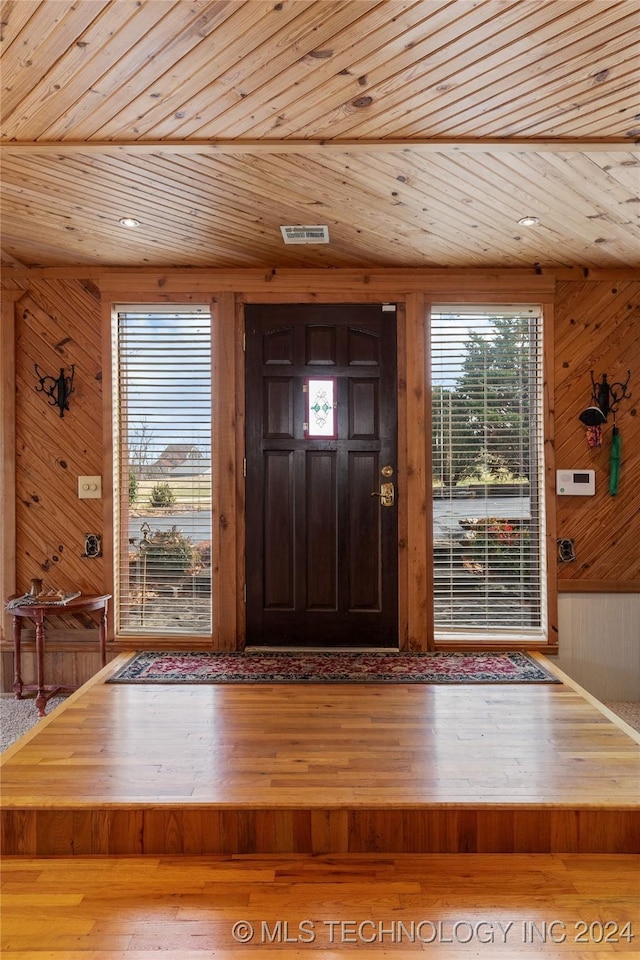 foyer featuring hardwood / wood-style floors, wooden walls, and wood ceiling