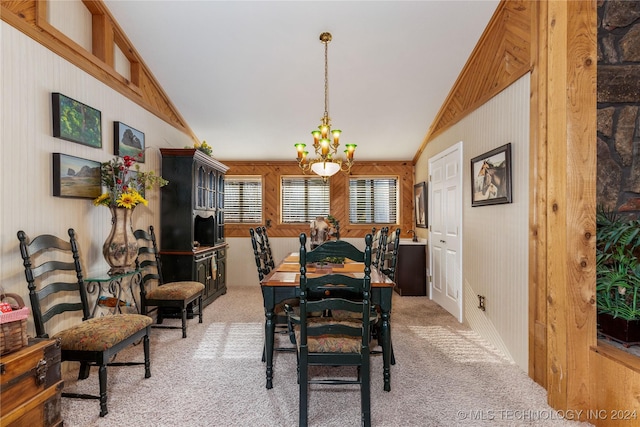 dining space with light carpet, wood walls, lofted ceiling, and a notable chandelier