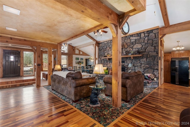 living room featuring vaulted ceiling with beams, wood-type flooring, and a fireplace