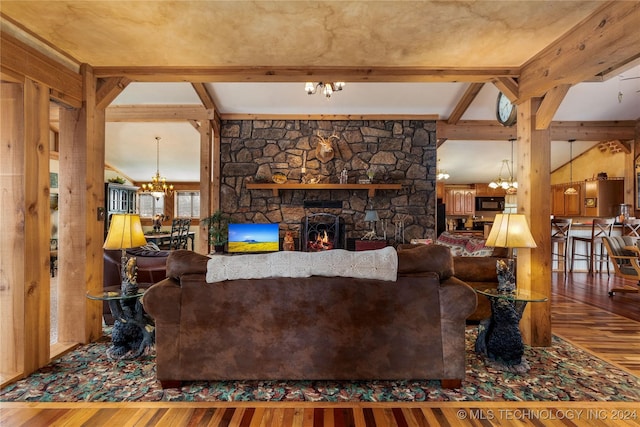 living room featuring a stone fireplace, hardwood / wood-style floors, and beamed ceiling