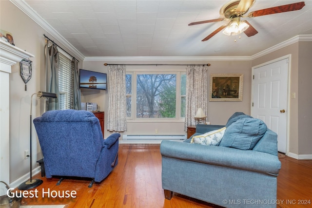 sitting room featuring baseboard heating, ceiling fan, hardwood / wood-style floors, and ornamental molding