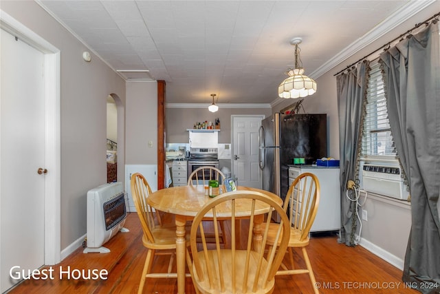 dining area with heating unit, hardwood / wood-style floors, cooling unit, and ornamental molding