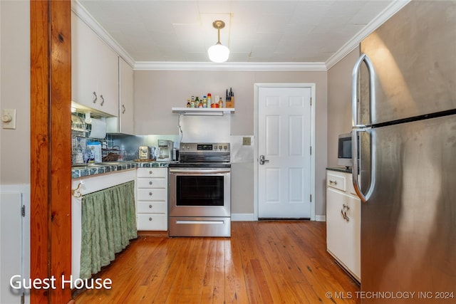 kitchen featuring white cabinets, ornamental molding, stainless steel appliances, and light hardwood / wood-style flooring