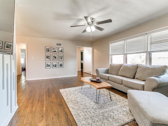 living room featuring ceiling fan and dark wood-type flooring