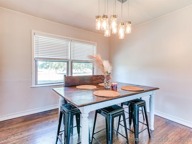 dining area with crown molding and dark hardwood / wood-style flooring