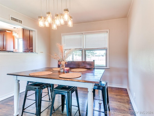 dining space with wood-type flooring and crown molding