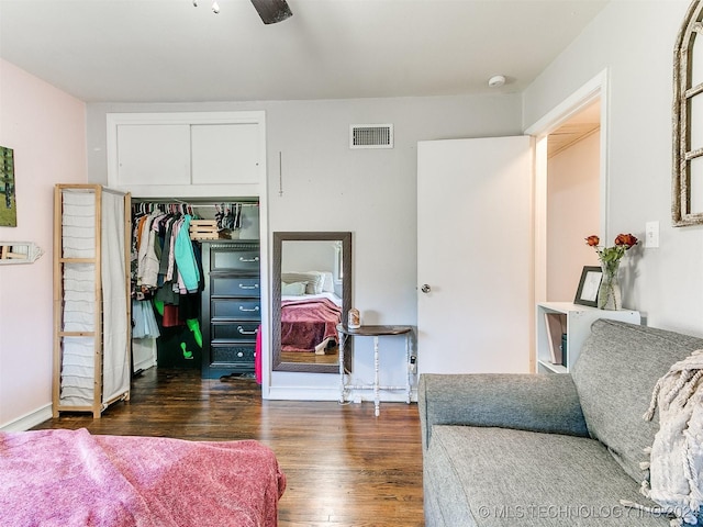 bedroom featuring ceiling fan, a closet, and dark wood-type flooring