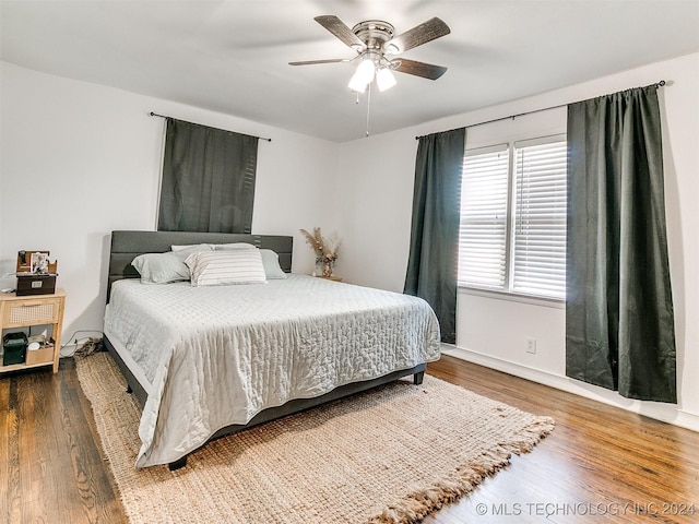 bedroom with dark hardwood / wood-style flooring and ceiling fan